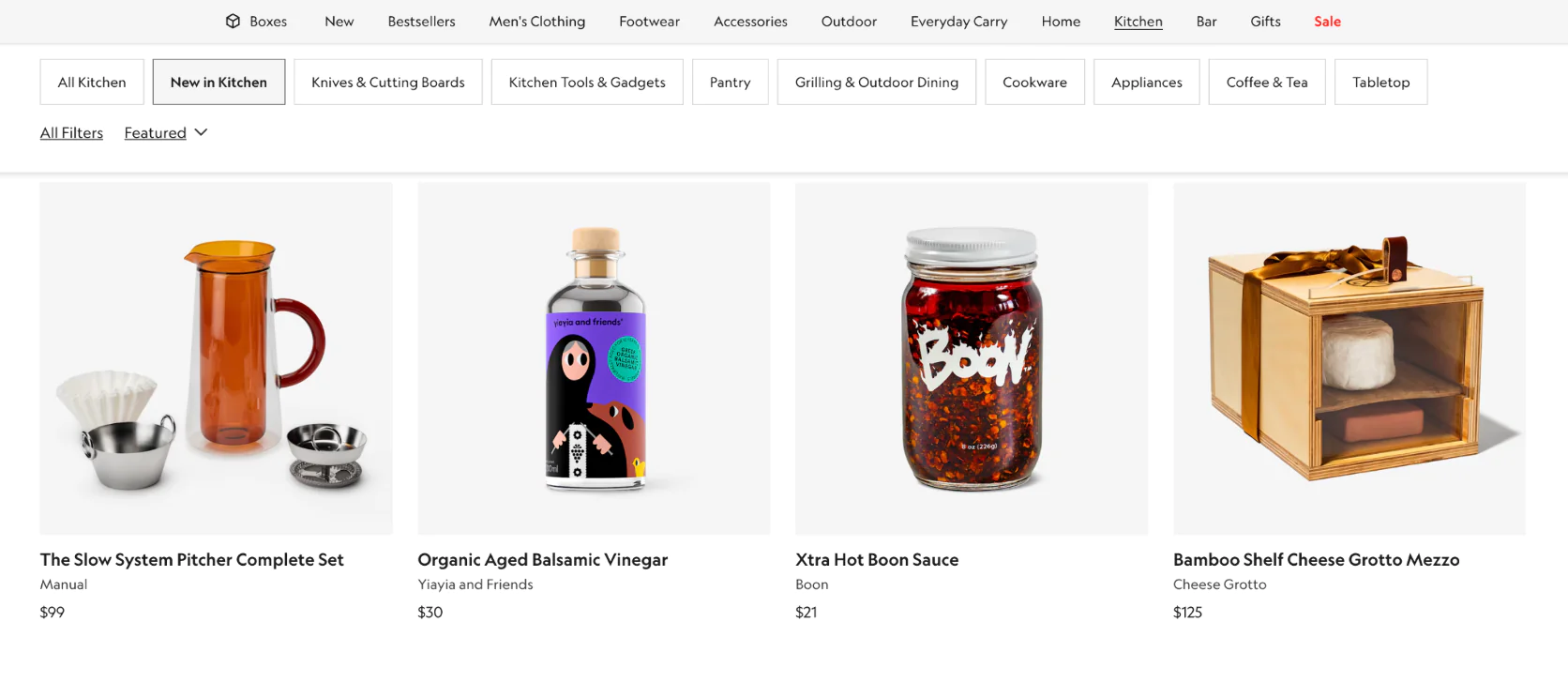 Image Bespoke Post's Kitchen collection displaying both durable goods (like the $99 pitcher set) and consumables (like hot sauce, vinegar) to fight subscriber fatigue